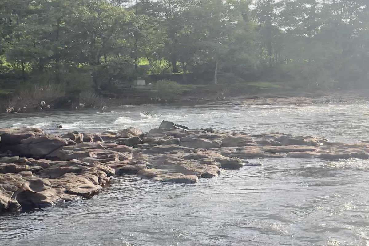 Serene river with flowing water over smooth rocks near MIDC area where riders stopped to refresh during the return journey from Diveagar to Pune