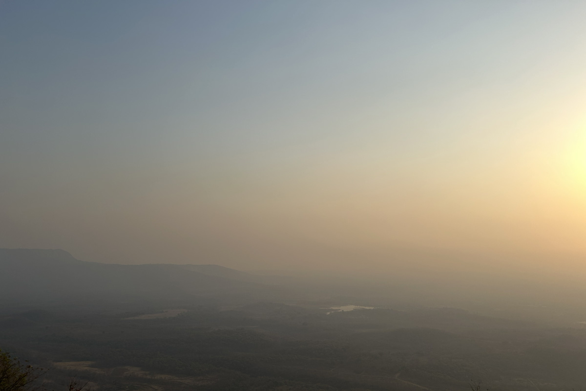 Breathtaking sunset view from Tamhini Ghat, with golden light filtering through the mountains